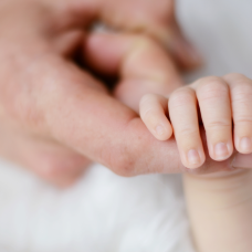 baby hand holding an adult's finger